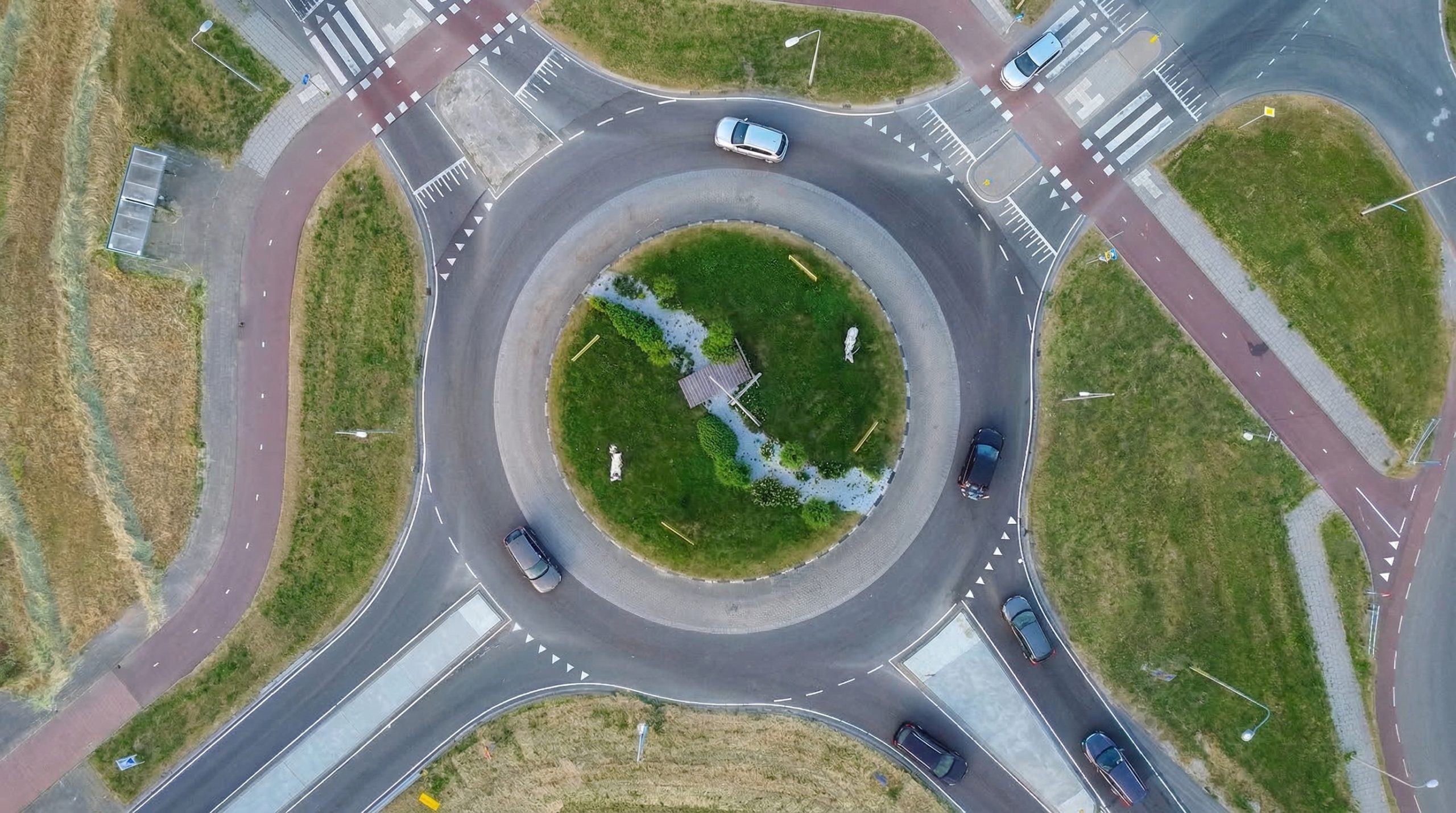 Luchtfoto recht van boven van een rotonde met zebrapaden en fietsoversteken